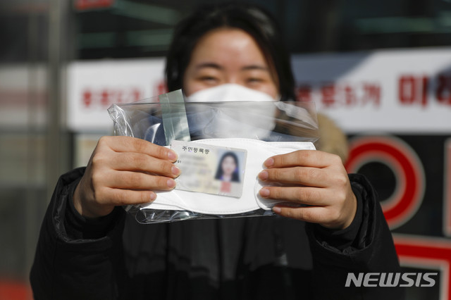 [서울=뉴시스] 박민석 기자 = 공적마스크 5부제 정책 시행 이후 첫 주말인 15일 오전 서울 종로구 종로5가 인근 약국에서 한 시민이 구매한 공적마스크와 신분증을 들고 있다. 2020.03.15.&nbsp; mspark@newsis.com 