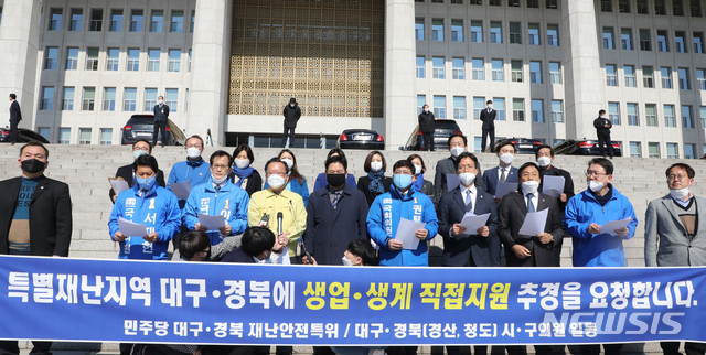 [서울=뉴시스]김명원 기자 = 더불어민주당 김부겸·홍의락·김현권 등 TK 의원들과 시구의원들이 16일 오전 서울 여의도 국회 본청 계단 앞에서 특별재난지역 대구·경북에 생업·생계 직접지원 추경을 요청하는 건의문 낭독을 하고 있다. 2020.03.16. kmx1105@newsis.com