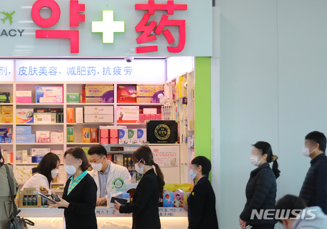 [제주=뉴시스]우장호 기자 = 마스크 5부제 둘째주인 16일 제주국제공항 내 약국에서 공항 이용객들이 공적마스크를 구매하기 위해 줄을 서 기다리고 있다. 2020.03.16. woo1223@newsis.com