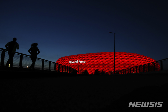[뮌헨=AP/뉴시스]16일(현지시간) 해가 진 독일 뮌헨의 '알리안츠 아레나' 축구 경기장 주변에서 시민들이 조깅하고 있다. 2020.0317. 