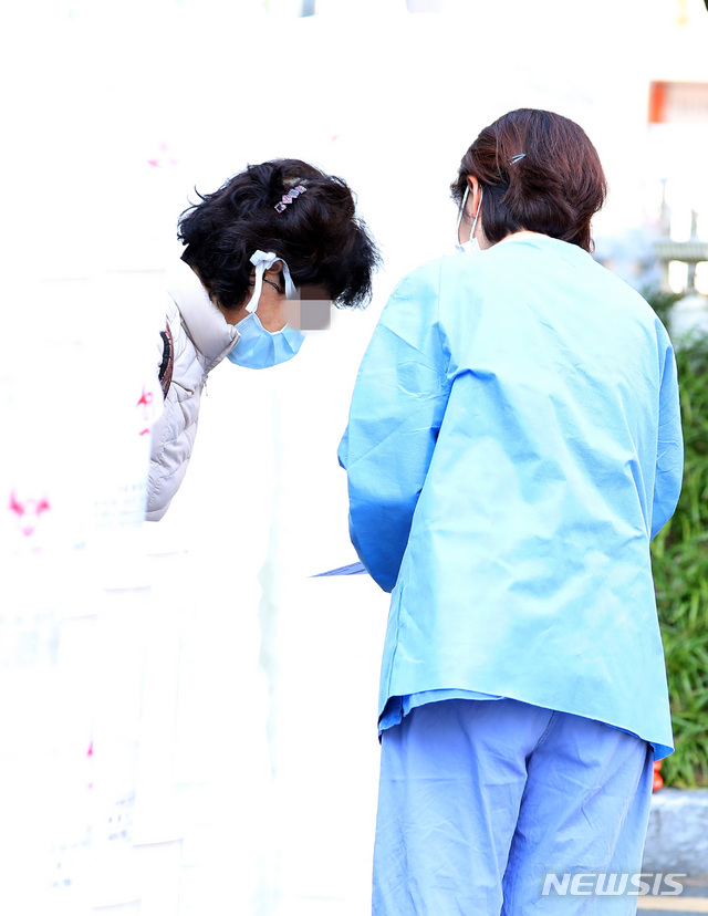 [대구=뉴시스]전신 기자 = 17일 대구 중구 계명대학교 대구동산병원에서 신종 코로나바이러스(코로나19) 확진 후 치료 받던 한 여성이 완치 후 퇴원하며 의료진에 인사하고 있다. 2020.03.17.&nbsp; photo1006@newsis.com