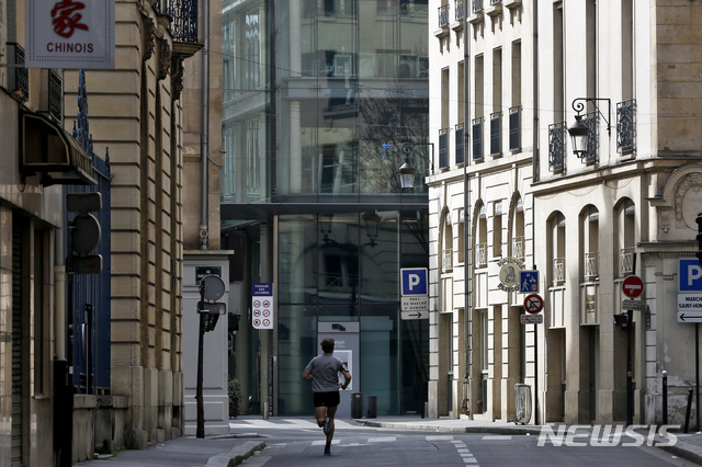  [파리=AP/뉴시스] 17일 정오부터 전국민 이동제한의 금족령이 내려진 프랑스 수도에서 17일 한 남성이 빈 거리를 달리고 있다. 집 부근에서 혼자서 하는 운동은 외출허가 사유가 되나 사유서를 작성해서 소지할 필요가 있다. 곳곳에서 단속하는 경찰과 군인들이 문건 제시를 요구한다. 2020. 3. 17.&nbsp;&nbsp; 