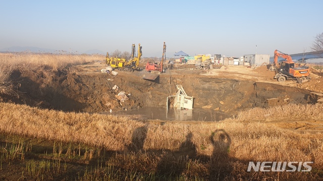 [부산=뉴시스] 18일 오전 5시 2분께 부산 사상구 삼락생태공원 오토캠핑장 인근 부전~마산간 복선경전철 공사현장에서 둘레 약 50m, 깊이 20m 크기로 지반이 무너져 시멘트 혼합기와 플렌트기 등 중장비가 물웅덩이에 침수됐다. (사진=부산경찰청 제공). 2020.03.18.photo@newsis.com