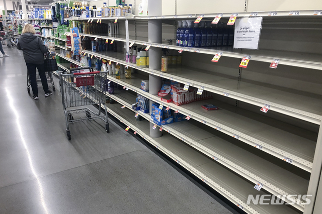 [워링턴=AP/뉴시스]지난 17일 미 펜실베이니아 워링턴 소재 한 상점에서 한 고객이 텅 빈 선반 근처를 둘러보고 있다. 2020.03.19.
