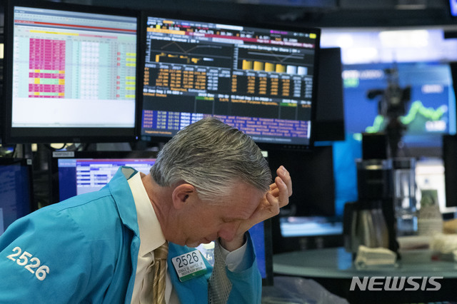 [뉴욕=AP/뉴시스]18일(현지시간) 뉴욕증권거래소(NYSE)에서 거래가 일시 중단되는 서킷 브레이커가 발동된 이후 한 트레이더가 이마를 짚고 있다. 2020.03.19.
