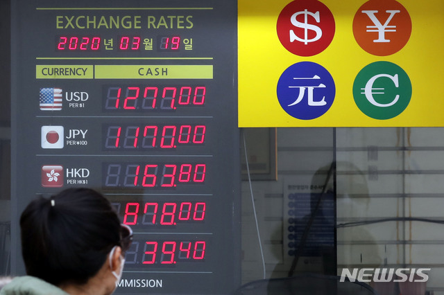 [서울=뉴시스] 최동준 기자 = 신종 코로나바이러스 감염증(코로나19) 사태로 원달러 환율이 폭등하는 등 금융시장이 요동치고 있는 19일 한 외국인이 서울 명동의 환전소 시세 전광판을 바라보고 있다. 2020.03.19.&nbsp; photocdj@newsis.com