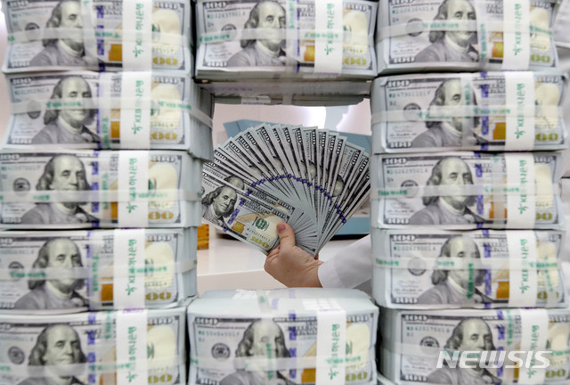 [서울=뉴시스]김병문 기자 = 한국은행과 미국 연방준비제도 양자 간 600억달러 규모의 통화 스와프 체결이 되면서 원·달러 환율이 하락세를 보이는 20일 오후 서울 중구 하나은행 위변조대응센터에서 한 직원이 달러를 검수하고 있다. 2020.03.20.&nbsp; dadazon@newsis.com