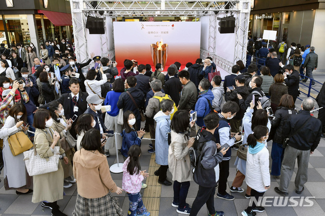 [센다이=AP/뉴시스]지난 21일 일본 미야기현 센다이에서 2020 도쿄올림픽 성화가 일반에 공개돼 성화를 보려는 주민들이 몰려들고 있다. 2020.03.21.  