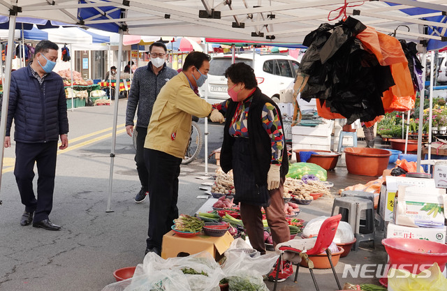 [창녕=뉴시스] 안지율 기자 = 한정우 경남 창녕군수는 22일 전통시장 5일장인 남지읍 남지시장을 찾아 신종 코로나바이러스 감염증(코로나19)으로 어려움을 겪는 시장상인과 팔꿈치 인사를 하고 있다.(사진=창녕군 제공) 2020.03.23.  photo@newsis.com