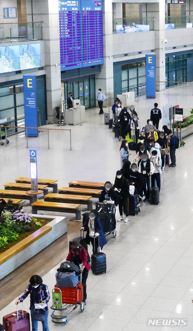 [인천공항=뉴시스]홍효식 기자 = 정부가 코로나19 관련 유럽발 입국자에 대한 검역을 강화한 가운데 23일 인천국제공항 1터미널에서 독일 프랑크푸르트 발 여객기를 타고 입국한 승객들이 격리시설로 이동하는 버스를 탑승하기 위해 줄지어 이동하고 있다. 2020.03.23. yesphoto@newsis.com