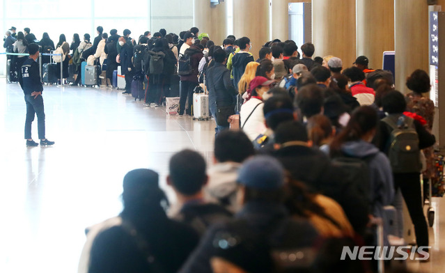 [인천공항=뉴시스]홍효식 기자 = 정부가 코로나19 관련 유럽발 입국자에 대한 검역을 강화한 가운데 23일 인천국제공항 1터미널에서 독일 프랑크푸르트 발 여객기를 타고 입국한 승객들이 격리시설로 이동하는 버스를 탑승하기 위해 줄지어 기다리고 있다. 2020.03.23. yesphoto@newsis.com