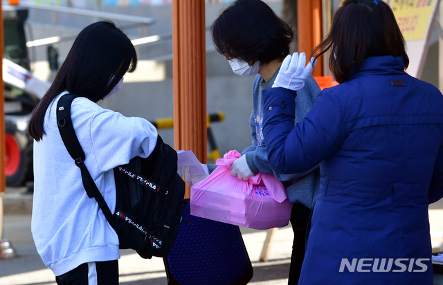 [광주=뉴시스] 류형근 기자 = 신종 코로나 바이러스 감염증(코로나19) 확산으로 초·중·고 개학이 연기된 가운데 24일 오전 광주 동구 한 고등학교에서 교사들이 학생에게 교과서를 배부하고 있다. 2020.03.24 hgryu77@newsis.com