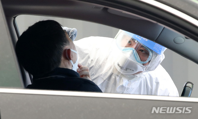 [서울=뉴시스] 고범준 기자 = 의료진들이 24일 서울 송파구 잠실주경기장에 마련된 드라이브 스루 신종 코로나바이러스 감염증(코로나19) 선별진료소에서 차량에 탑승한 시민을 검사하고 있다. 2020.03.24. bjko@newsis.com