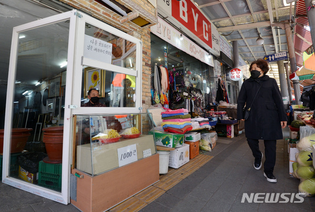 [대구=뉴시스] 이무열 기자 = 24일 오후 대구 동구 효목동 동구시장에서 한 상인이 신종 코로나바이러스 감염증(코로나19) 확산 방지를 위해 투명 가림판을 설치 후 콩나물을 판매하고 있다. 2020.03.24. lmy@newsis.com
