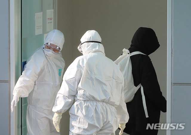 [제주=뉴시스] 우장호 기자 = 제주에서 코로나19 확진자가 발생한 24일, 제주대학교병원 음압병동으로 코로나19 양성 판정을 받은 20대 여성이 이송되고 있다. 2020.03.24 woo1223@newsis.com