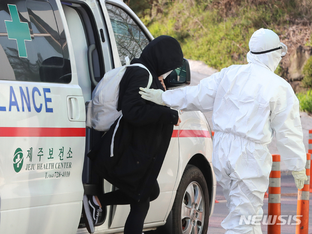 [제주=뉴시스]우장호 기자 = 신종 코로나바이러스 감염증(코로나19) 양성판정을 받은 20대 여성이 지난달 제주의 한 병원 음압병동으로 이송되고 있다. 2020.03.24. woo1223@newsis.com