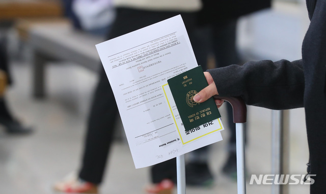 [인천공항=뉴시스]전신 기자 = 24일 인천국제공항 제2여객터미널에서 유럽발 내국인 입국자가 격리통지서를 들고 있다. 정부는 유럽발 신종 코로나 바이러스 감염증(코로나19) 유증상자 증가에 대비해 무증상 내국인은 당초 시설격리에서 자가격리로 전환하기로 했다. 2020.03.24.  photo1006@newsis.com