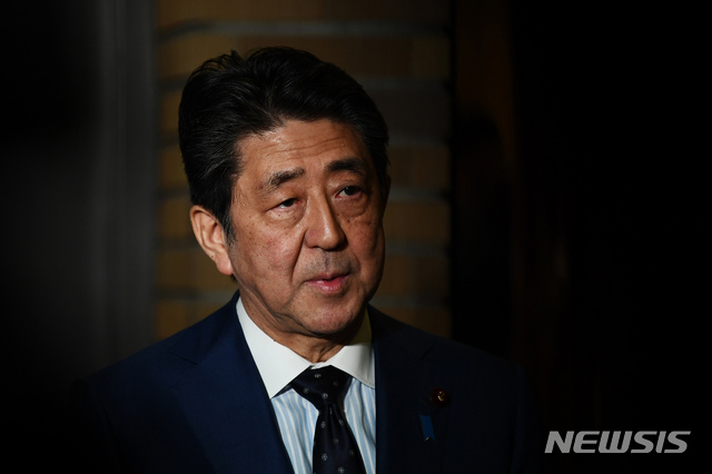 Japan's Prime Minister Shinzo Abe talks to journalists in front of the prime minister's residence in Tokyo, Tuesday, March 24, 2020. Abe says IOC president has agreed "100%" to proposal of postponing Olympics for about 1 year. (Charly Triballeau/Pool Photo via AP)