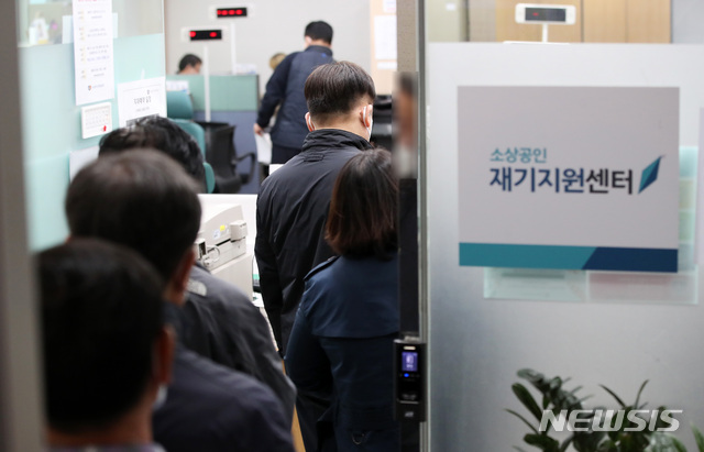 [서울=뉴시스] 고범준 기자 = 신종 코로나바이러스 감염증(코로나19)으로 피해를 입은 소상공인에 대한 경영안정자금 직접대출 접수가 시작된 25일 오후 서울 종로구 소상공인시장진흥공단 서울중부센터에서 소상공인들이 접수를 위해 줄 서 있다. 2020.03.25. bjko@newsis.com