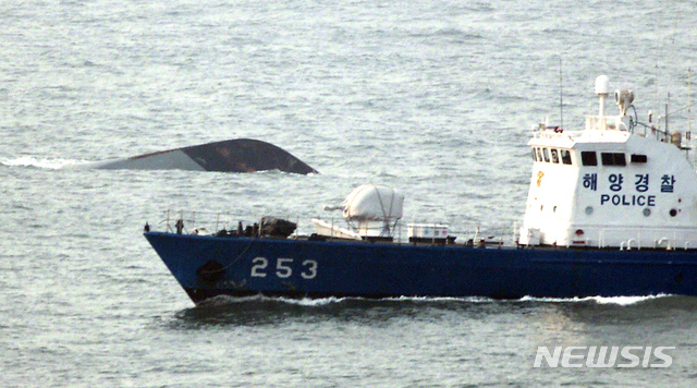 [인천=뉴시스] 강종민 기자 = 지난 2010년 3월 서해 백령도 서남방 1.8㎞ 해상에서 침몰한 1200t급 초계함 천안함의 선수 부분이 수면위로 보이고 있는 가운데 해경 함선이 주변을 지나고 있다. (사진=옹진군청 제공) photo@newsis.com 