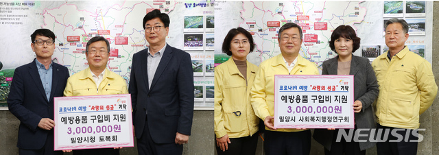 [밀양=뉴시스] 경남 밀양시청 토목회(왼쪽)와 사회복지 행정연구회가 코로나19 조기 극복을 위한 성금 5000만원을 전달하고 있다.(사진=밀양시 제공) 2020.03.26. photo@newsis.com