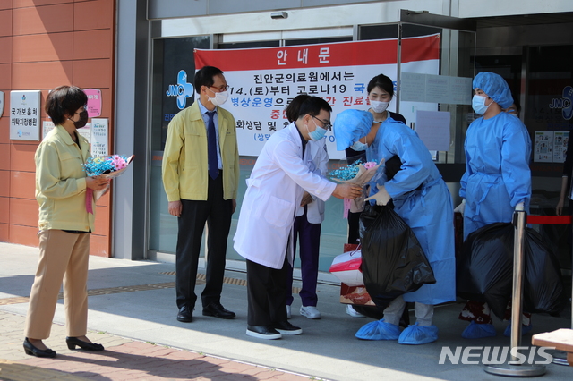 [진안=뉴시스] 한훈 기자 = 지난달 대구에서 전북 진안군의 한 병원으로 이송된 코로나19 경증 환자가 완치돼 의료진과 작별인사를 하고 있다. (사진=진안군 제공).2020.03.26. photo@newsis.com