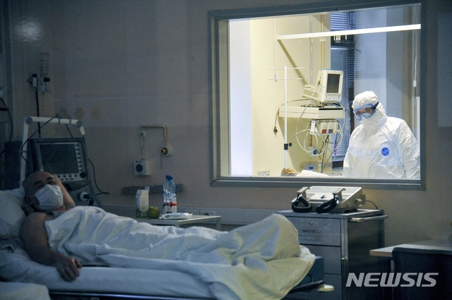 [모스크바=AP/뉴시스]지난 3월25일 러시아 모스크바의 스켈리포스프스키 병원에서 의사 1명이 유리창 너머로 신종 코로나바이러스 감염증(코로나19) 환자의 상태를 관찰하고 있다. 러시아 의회는 31일(현지시간) 검역 규정을 위반해 다른 사람을 코로나19에 걸리게 하고 그로 인해 감염자가 숨질 경우 징역 7년형을 선고할 수 있도록 하는 내용의 "바이러스 방지법"을 승인했다. 2020.4.1