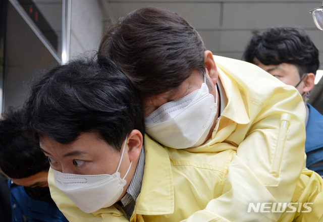 [대구=뉴시스] 이무열 기자= 권영진 대구시장이 26일 오후 대구시의회에서 열린 제273회 임시회에 참석 후 민주당 이진련(비례) 시의원이 코로나19 긴급생계비를 4·15 총선 이후 지급한다고 한 것에 대해 비판하자 "제발 좀 그만하세요"라고 말하며 쓰러진 뒤 직원 등에 업힌 채 의회를 빠져나가고 있다. 2020.03.26 lmy@newsis.com