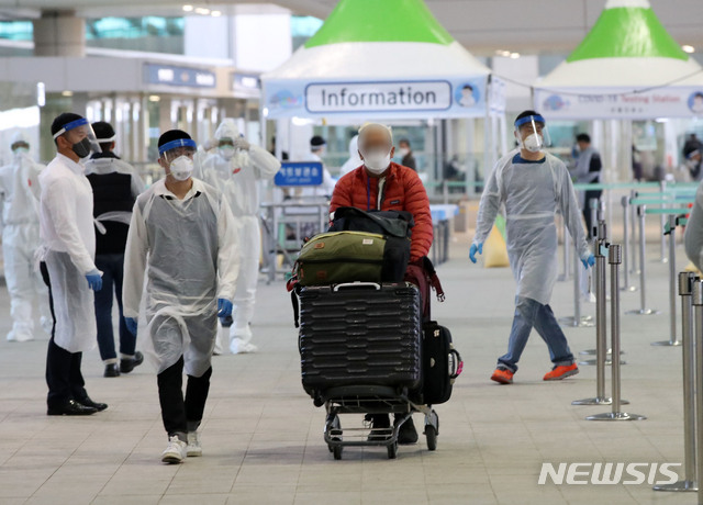 [인천공항=뉴시스] 고범준 기자 = 26일 오후 인천국제공항 제2터미널 옥외공간에 마련된 신종 코로나바이러스 감염증(코로나19) 개방형 선별진료소가 설치되어 있는 가운데 영국 런던발 여객기를 타고 온 외국인이 진단검사를 받고 이동하고 있다. 2020.03.26. bjko@newsis.com