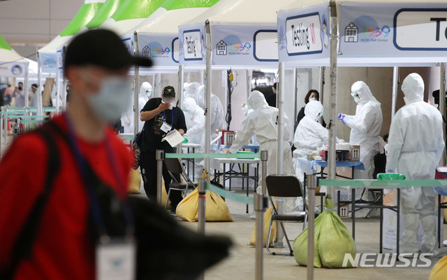[인천공항=뉴시스] 고범준 기자 = 26일 오후 인천국제공항 제2터미널 옥외공간에 마련된 신종 코로나바이러스 감염증(코로나19) 개방형 선별진료소가 설치되어 있는 가운데 영국 런던발 여객기를 타고 온 외국인이 진단검사를 받고 있다. 2020.03.26. bjko@newsis.com