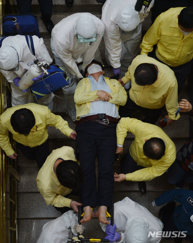 [대구=뉴시스] 이무열 기자 = 권영진 대구시장이 26일 오후 대구시의회에서 열린 273회 임시회 본회의를 마치고 퇴장하던 도중 이진련 의원의 질타를 듣다 어지러움증을 호소하며 쓰러지고 있다. 2020.03.26.lmy@newsis.com