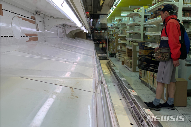 [도쿄=AP/뉴시스]지난 26일 일본 도쿄의 한 식료품점의 빈 선반을 시민이 바라보고 있다. 지난 25일 도쿄도가 외출 자제를 요청하자 도쿄에서는 사재기 바람이 불고있다. 2020.03.27.