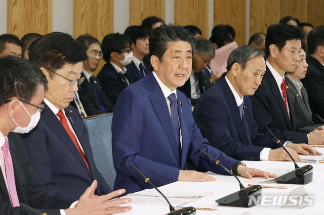 [도쿄=AP/뉴시스]아베 신조 일본 총리(가운데)가 지난 26일 총리 관저에서 특별조치법에 근거한 코로나19 관련 대책 본부를 설치한 후 첫 회의를 가지고 있다. 회의에는 가토 가쓰노부 후생노동상, 니시무라 야스토시(西村康稔) 경제재정·재생상, 스가 요시히데 관방장관 등이 참석했다. 대책 본부 설치로 아베 총리는 긴급 사태 선언이 가능해졌다. 2020.03.29