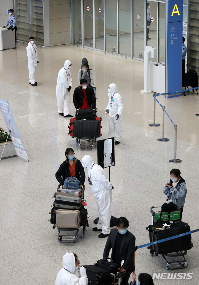[인천공항=뉴시스] 고범준 기자 = 신종 코로나바이러스 감염증(코로나19) 무증상자의 안전 귀가를 위해 해외입국자 전용 KTX칸과 공항버스가 운행되고 있는 가운데 29일 오후 인천국제공항 제2터미널에서 독일 프랑크푸르트와 영국 런던 발 여객기를 타고 입국한 승객들이 방역관계자들에게 KTX와 지방 이동 등에 대한 안내를 받고 있다. 2020.03.29.&nbsp; bjko@newsis.com