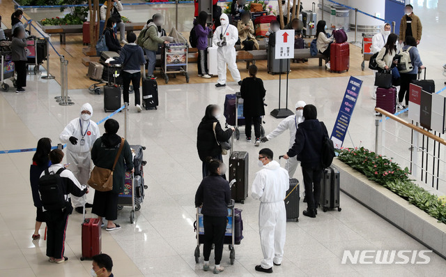 [인천공항=뉴시스] 고범준 기자 = 신종 코로나바이러스 감염증(코로나19) 무증상자의 안전 귀가를 위해 해외입국자 전용 KTX칸과 공항버스가 운행되고 있는 가운데 29일 오후 인천국제공항 제2터미널에서 독일 프랑크푸르트와 영국 런던 발 여객기를 타고 입국한 승객들이 방역관계자들에게 KTX와 지방 이동 등에 대한 안내를 받고 있다. 2020.03.29. bjko@newsis.com