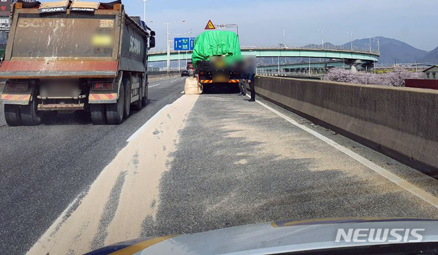 [부산=뉴시스] 30일 오전 10시 38분께 부산 사상구 관문대로 삼락나들목 인근을 달리던 화물차 적재함에서 가축사료를 넣은 포대 36개 중 1개(50㎏)가 도로로 떨어졌다. (사진=부산경찰청 제공)