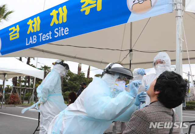 [제주=뉴시스]우장호 기자 = 신종 코로나바이러스 감염증(코로나19)이 확산 중인 30일 제주국제공항 내에 마련된 워킹 스루 진료소(개방형 선별진료소)에서 국외 입국자를 대상으로 코로나19 검사가 진행되고 있다. 2020.03.30. woo1223@newsis.com