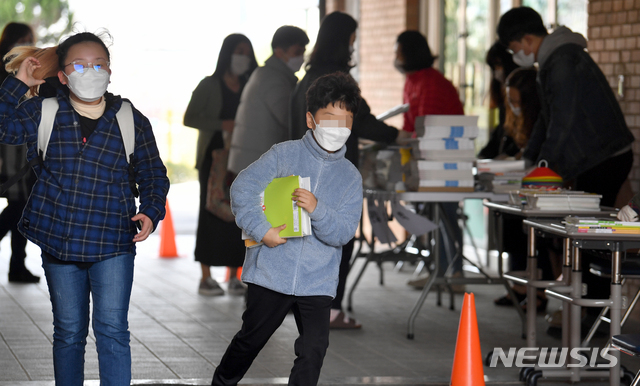 [광주=뉴시스] 류형근 기자 = 신종 코로나 바이러스 감염증(코로나19)이 지속되고 있는 가운데 30일 오전 광주 서구 광천초등학교에서 한 어린이가 교재를 받은 뒤 돌아가고 있다. 2020.03.30. hgryu77@newsis.com