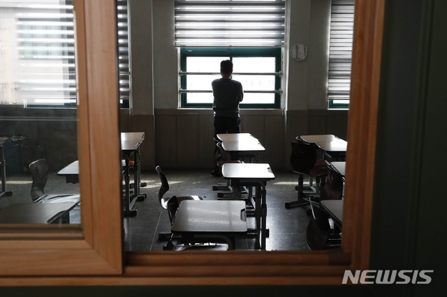 [서울=뉴시스] 박민석 기자 = 신종 코로나바이러스 감염증(코로나19)의 여파로 2021학년도 대학수학능력시험이 2주 연기된 31일 오후 서울 종로구 대신고등학교에서 고3 담임선생님이 빈 교실에서 창밖을 바라보고 있다. 2020.03.31. mspark@newsis.com