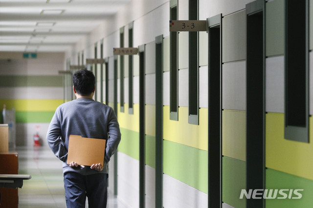 [서울=뉴시스] 박민석 기자 = 신종 코로나바이러스 감염증(코로나19)의 여파로 2021학년도 대학수학능력시험이 2주 연기된 31일 오후 서울 종로구 대신고등학교에서 고3 담임선생님이 비어있는 복도를 걷고 있다. 2020.03.31.   mspark@newsis.com