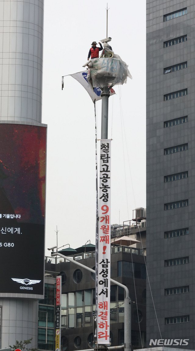[서울=뉴시스] 고범준 기자 = 삼성 해고노동자 김용희 씨가 31일 오후 고공농성중인 서울 강남역 사거리 인근 철탑에서 심상정 정의당 대표를 만나기 앞서 투쟁을 외치고 있다. 2020.03.31.&nbsp; bjko@newsis.com