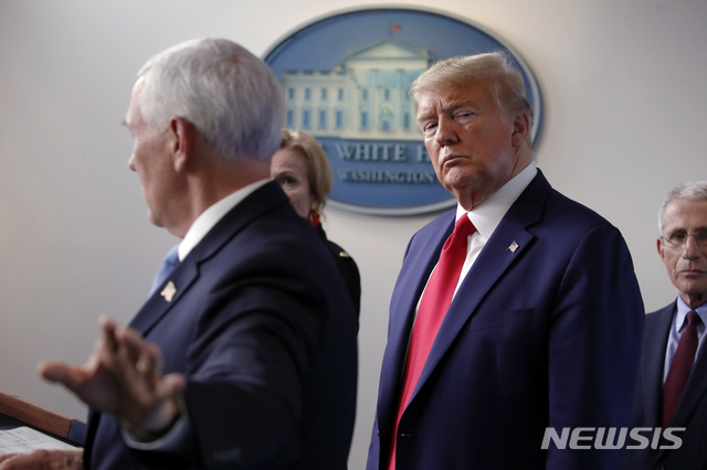 [워싱턴=AP/뉴시스]도널드 트럼프 미국 대통령(오른쪽)이 31일(현지시간) 백악관 브리핑룸에서 마이크 펜스 부통령의 신종 코로나바이러스 감염증(코로나19) 정례 기자회견 발언을 지켜보고 있다. 2020.04.01. 
