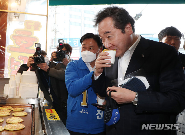 [수원=뉴시스] 김진아 기자 = 이낙연 더불어민주당 공동 상임선대위원장이 김영진 수원병 후보와 1일 오전 경기 수원 못골시장에서 호떡을 먹고 있다. 2020.04.01. bluesoda@newsis.com