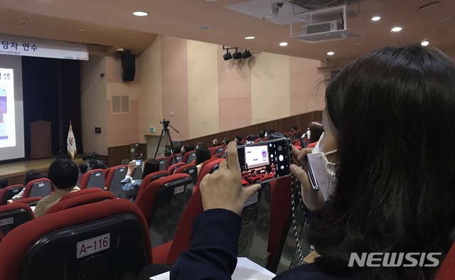 [울산=뉴시스] 구미현 기자 = 2일 오전 울산시교육청 대강당에서 열린 '원격수업 교사 연수'에 참석한 한 고등학교 교사가 휴대전화로 강의 내용을 촬영하고 있다. 2020.04.02. gorgeouskoo@newsis.com