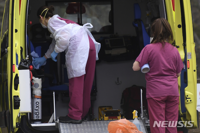 [런던=AP/뉴시스] 1일(현지시간) 영국 런던의 세인트 토머스 병원의 의료진들이 응급차량을 닦고 있다. 이날 영국의사협회(BMA)는 신종 코로나바이러스 감염증(코로나19)의 확산으로 의료체제가 과부하에 걸리면 '젊고 더 상태가 좋은' 환자를 먼저 치료하라는 의료 지침을 내놨다. 2020.4.2.