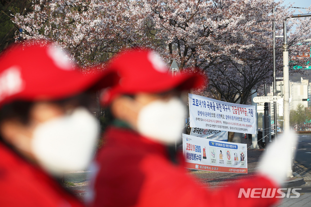 [대구=뉴시스] 이윤청 기자 = 선거운동원들이 3일 대구 수성구 두산오거리에서 선거유세를 하고 있다. 그 뒤로 코로나19 극복을 위한 긴급생계자금 지원 안내 현수막과 벚꽃이 보인다. 2020.04.03. radiohead@newsis.com