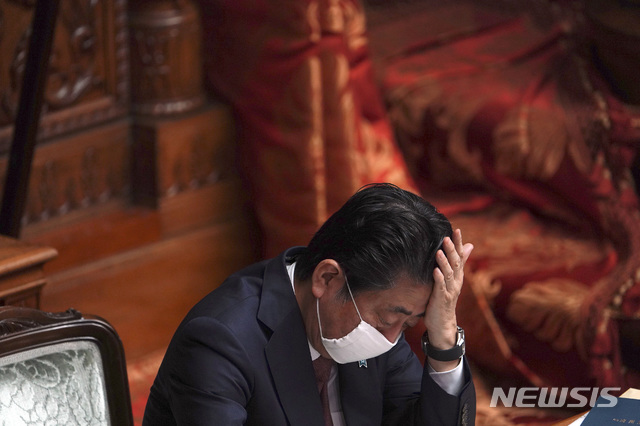  [도쿄=AP/뉴시스]신종 코로나바이러스 감염증 예방을 위해 마스크를 쓴 아베 신조 일본 총리가 3일 일본 도쿄에서 열린 국회 상원 본회의에 참석해 이마를 만지고 있다. 아베 총리는 지난 1일 코로나19 정부 대책 본부 회의에서 가구당 천 마스크 2개를 배포하겠다는 방침을 발표했다가 거센 비난에 직면한 바 있다. 2020.04.03. 