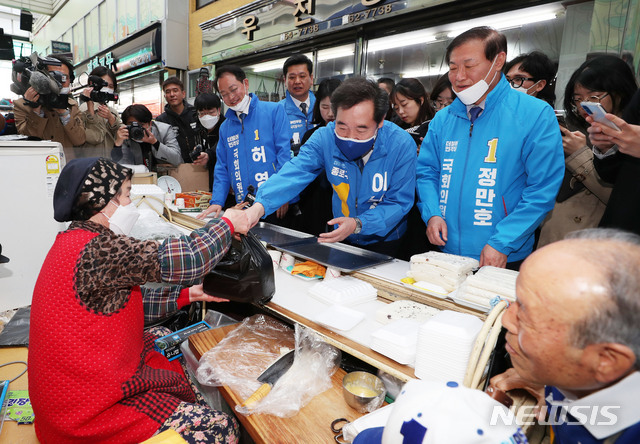 [춘천=뉴시스] 김진아 기자 = 이낙연 더불어민주당 공동상임선대위원장이 허영 춘천철원화천양구갑 후보, 춘천철원군화천군양구을 정만호 후보와 3일 강원도 춘천 제일 중앙시장에서 떡을 구매하고 있다.2020.04.03. bluesoda@newsis.com
