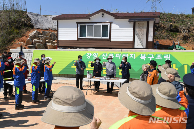 [강릉=뉴시스]배훈식 기자 = 문재인 대통령과 김정숙 여사가 5일 식목일을 맞아 지난해 대형 산불로 피해를 입은 강원 강릉시 옥계면 천남리 재조림 지역을 방문해 산림청 직원을 비롯한 식목행사 참여자들과 파이팅을 외치고 있다. 2020.04.05.&nbsp; dahora83@newsis.com