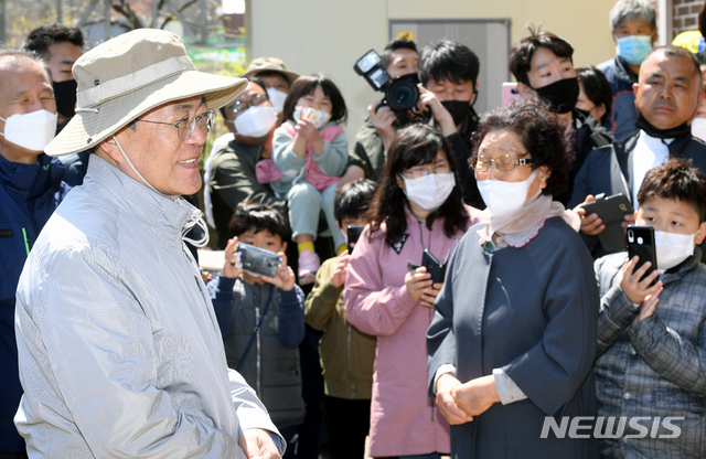 [강릉=뉴시스]배훈식 기자 = 문재인 대통령이 5일 식목일을 맞아 지난해 대형 산불로 피해를 입은 강원 강릉시 옥계면 천남리 재조림 지역을 방문해 금강 소나무를 심은 뒤 마을 주민을 위로하고 있다. 2020.04.05. dahora83@newsis.com